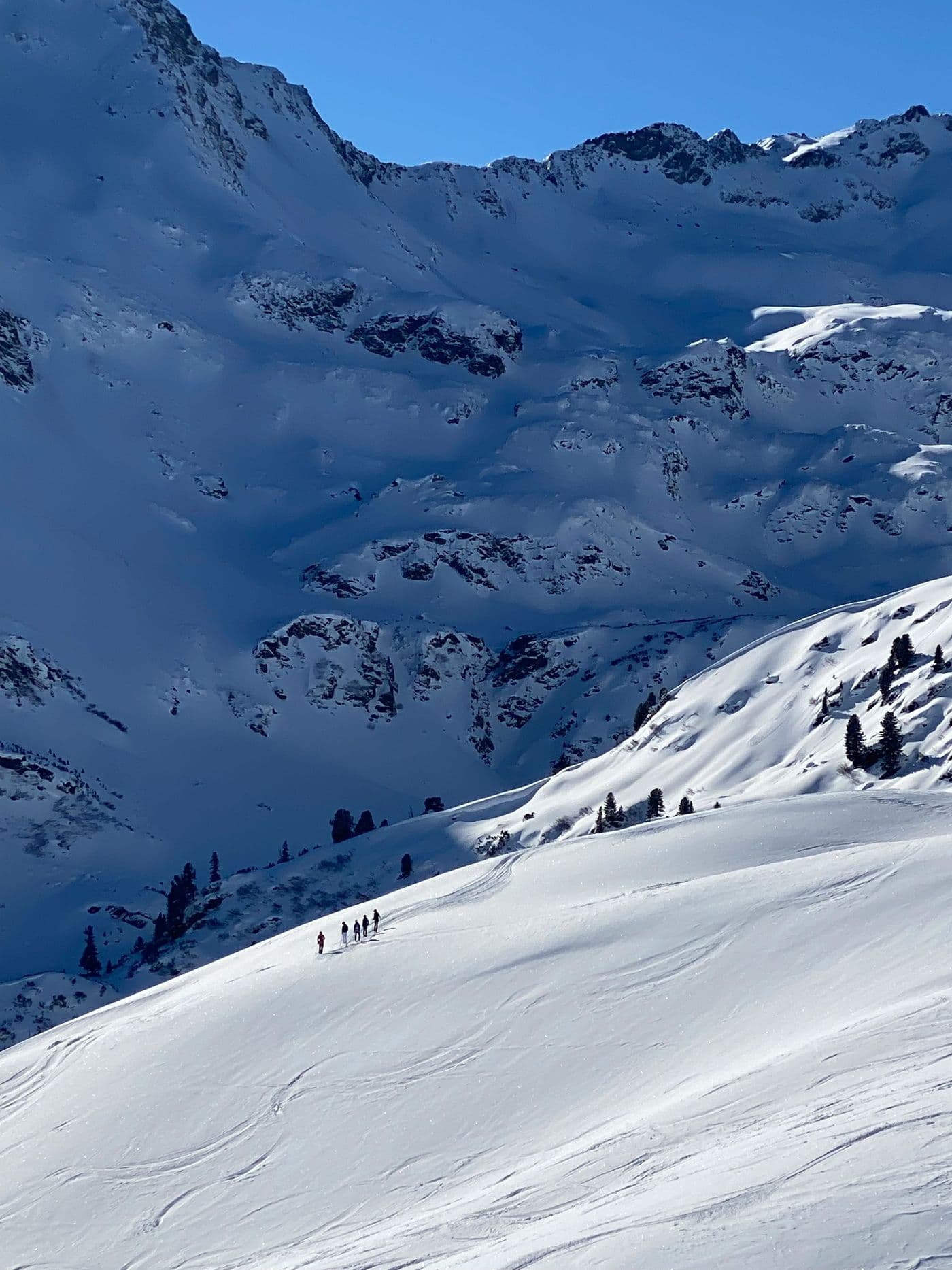 Skiers heading down a snowy slope